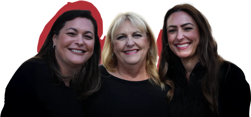 Three women with long dark and blonde hair, all smiling, stand close together in front of a white background with red silhouettes behind them.