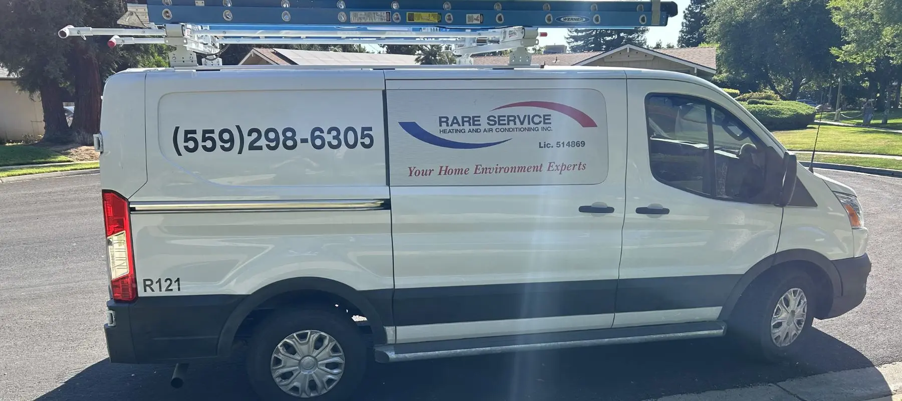 A white van with a ladder on top, displaying the company name Rare Service for HVAC, a phone number, and the slogan Your Home Environment Experts, is parked on a sunny residential street.